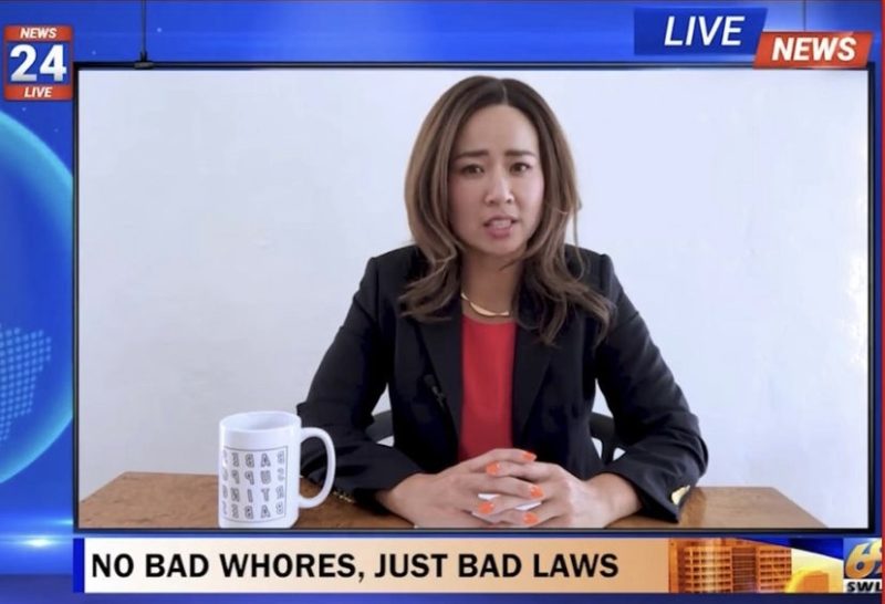In a news headline, there is an image of Kim Ye sitting at a desk with a mug with their hands interlaced. In the top right corner it reads "LIVE NEWS." Below the image a headline is written "NO BAD WHORES, JUST BAD LAWS"